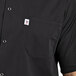 A man wearing a black Uncommon Chef cook shirt with snaps and a pocket.