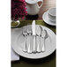 A white plate with a Sant'Andrea Bellini stainless steel salad/dessert fork on it, next to a flower.