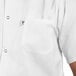 A man wearing a white Uncommon Chef cook shirt with a pocket. The pocket has a logo.