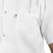 A man wearing a white Uncommon Chef cook shirt with a pocket.