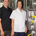 A man and woman standing next to each other, both wearing white Uncommon Chef snap cook shirts.