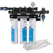 A Hoshizaki water filtration system with three white and blue cartridges.
