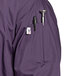 A close-up of the pocket on a purple Uncommon Chef 3/4 Length Sleeve Chef Coat.
