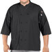A man wearing a black Uncommon Chef 3/4 length sleeve chef coat.