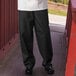 A person wearing Uncommon Chef black pants and a white shirt.