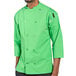 A man wearing a lime green Uncommon Chef coat with black pants.