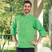 A man wearing a lime green Uncommon Chef 3/4 Sleeve Chef Coat.