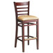 A Lancaster Table & Seating mahogany wood bar stool with a light brown cushioned seat.