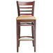 A Lancaster Table & Seating mahogany wood bar stool with light brown vinyl seat.