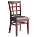 A Lancaster Table & Seating mahogany wood window back chair with a dark brown leather seat.