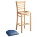 A Lancaster Table & Seating wooden ladder back bar stool with a navy vinyl seat on it.