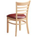 A Lancaster Table & Seating wooden ladder back chair with a burgundy vinyl seat.
