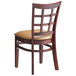 A Lancaster Table & Seating mahogany wood chair with a light brown vinyl cushion.