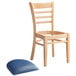 A Lancaster Table & Seating wooden chair with a navy blue vinyl seat