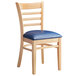 A Lancaster Table & Seating wooden ladder back chair with a navy vinyl seat.