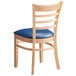 A Lancaster Table & Seating wooden chair with blue vinyl seat and ladder back.