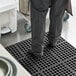 A person standing on a black Choice anti-fatigue floor mat.