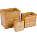 An American Metalcraft dark bamboo riser set with three wooden containers and lids.