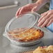 A hand holding a Choice clear plastic container with a pie in it.