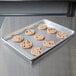 A Vollrath Wear-Ever aluminum bun pan with perforations holding a tray of cookies.