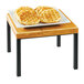 A Cal-Mil Madera rustic pine wood riser with waffles on a plate on a table.