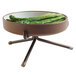 A Cal-Mil bronze plate stand holding a bowl of asparagus on a table.