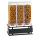 A Cal-Mil triple canister cereal dispenser filled with a variety of cereals.