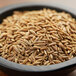 A bowl of Regal Cumin Seeds on a wooden table.