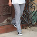 A person wearing Uncommon Chef Houndstooth Classic Chef Pants and sneakers.