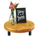 A Cal-Mil Madera wood riser on a table with a sign and a glass vase of flowers.