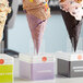 A row of Konery lavender waffle ice cream cones on a counter display.