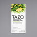 A white Tazo box with green leaves and ginger and a black circle with white text reading "Green Ginger" with images of ginger and lemon.