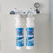 A C Pure Oceanloch-L2 dual water filtration system attached to a wall with blue Oceanloch-L2 labels.