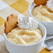Two bowls of LeGout vanilla cream pudding with whipped cream and cookies.