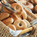 A basket filled with Original Bagel New York style mini bagels on a table in a bakery display.