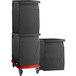 A stack of black Cambro storage boxes on a red Camdolly.