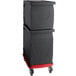 A stack of black Cambro food pan carriers on a black Camdolly with red trim.