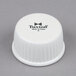 A white plastic lid with black text that reads "Tuxton" for a Tuxton white china ramekin.