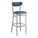 A Lancaster Table & Seating bar stool with a blue vinyl seat and back on a silver metal frame.