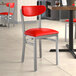 A Lancaster Table & Seating red vinyl chair on a restaurant table.