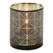 A black and gold geometric glass votive candle holder with a lit candle inside.