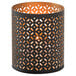 A black metal Monarch votive holder with a gold geometric design holding a lit candle.