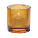 A Hollowick round amber glass tealight holder with a jewel design.