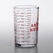 An Anchor Hocking glass measuring cup with red print for 5 oz. on a kitchen counter.
