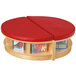 A Jonti-Craft Baltic Birch Read-a-Round full-circle table with red cushioned seating and clear trays.