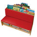A red cushioned corner literacy nook with books on it.