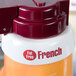 A close up of a white Tablecraft plastic dispenser collar with maroon lettering.