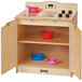 A Jonti-Craft wooden toddler kitchen stove with bowls on a table.