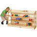 A young boy pushing a Jonti-Craft wood storage cabinet.