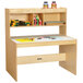 A Jonti-Craft children's wood dual writing desk with a shelf and stationery.